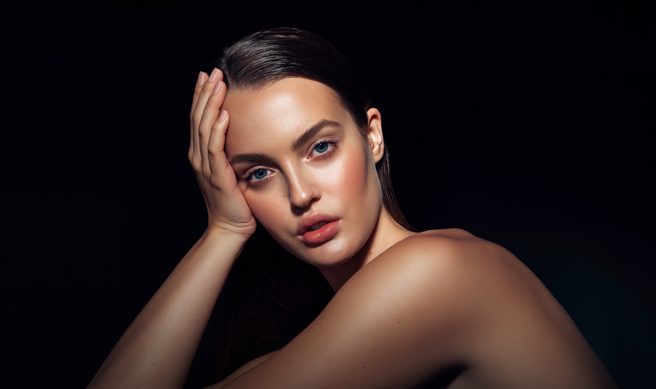 Bellevue plastic surgery model with hand on her head